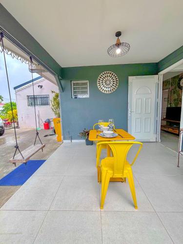 a yellow table and chairs on a patio at La place de l'Apéro in Ducos