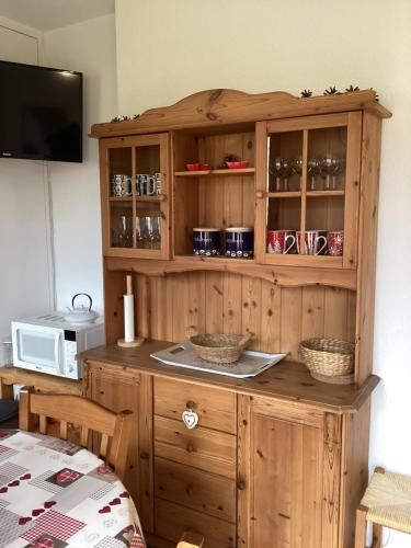 Cette chambre dispose d'une armoire en bois et d'un four micro-ondes. dans l'établissement T2 cosy Eglantier Chalet de SuperD, à Saint-Étienne-en-Dévoluy