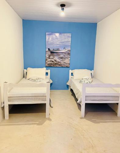 two beds in a room with blue walls at Pousada Marina Pecém in São Gonçalo do Amarante