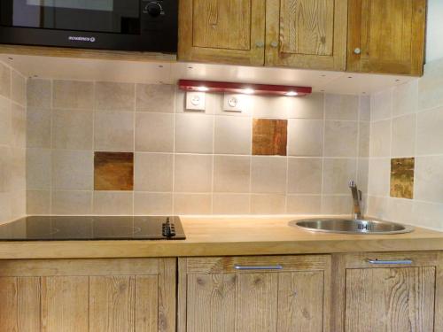 un comptoir de cuisine avec un évier et un micro-ondes dans l'établissement Appartement cosy, skis aux pieds, 4 pers., proche commerces et écoles de ski - FR-1-182-99, à Méribel