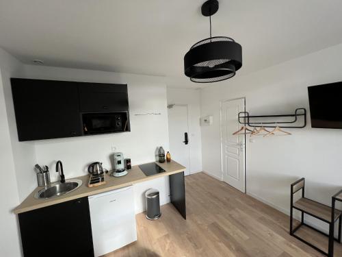 a kitchen and living room with a sink and a table at Le Cosy, 2P Centre-ville in Liévin