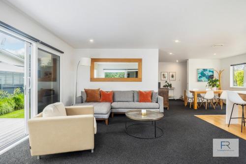 a living room with a couch and a table at Stylish Northcote Point Bungalow in Auckland