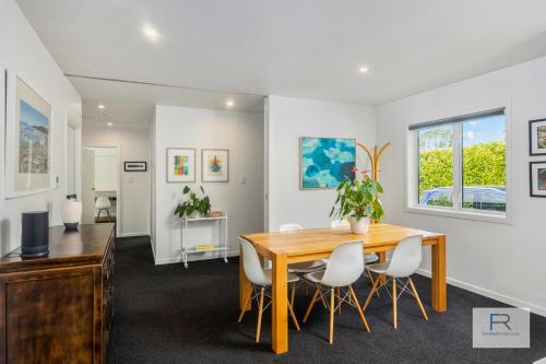 a dining room with a wooden table and chairs at Stylish Northcote Point Bungalow in Auckland