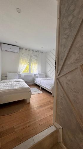 une chambre avec deux lits et une fenêtre dans l'établissement Appartement de luxe, à Bussières-lès-Belmont