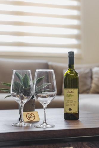 a bottle of wine and two wine glasses on a table at Harmony Apartments in Podgorica
