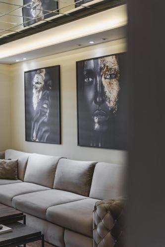 a living room with a couch and two pictures on the wall at Harmony Apartments in Podgorica