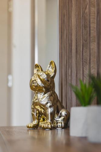 a gold figurine of a dog sitting on a table at Harmony Apartments in Podgorica