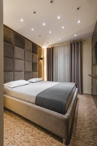 a bedroom with a large bed in a room at Harmony Apartments in Podgorica