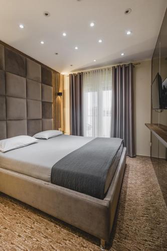 a bedroom with a large bed in a room at Harmony Apartments in Podgorica