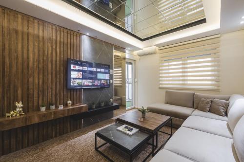 a living room with a couch and a tv at Harmony Apartments in Podgorica