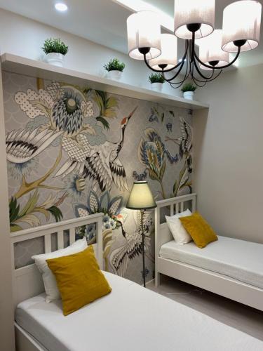 a bedroom with two beds and a wallpaper with birds at MOM Boutique Rooms in Budapest