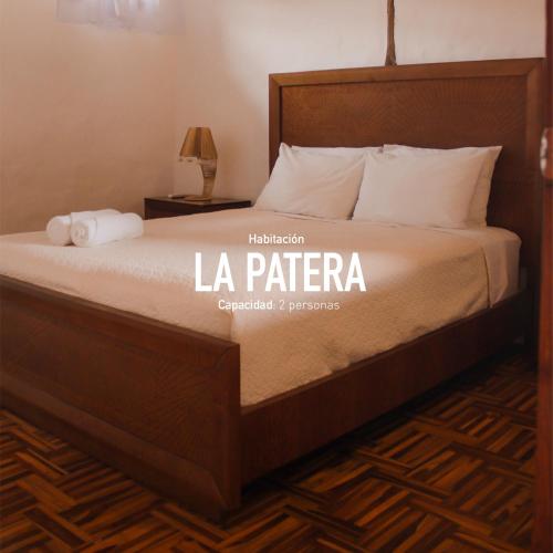 a bed in a hotel room with the words la patera at Ayampe Guest House in Ayampe