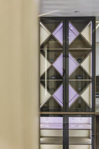 a glass display cabinet with purple glass panels at Harmony Apartments in Podgorica