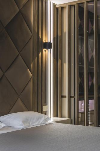 a bedroom with a bed and a glass door with a window at Harmony Apartments in Podgorica