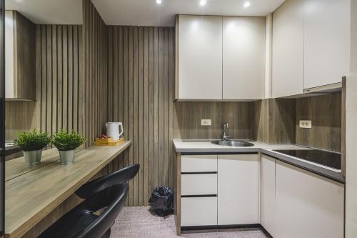 a kitchen with white cabinets and a sink at Harmony Apartments in Podgorica