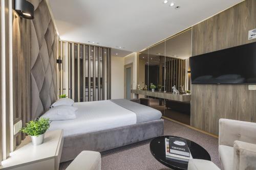 a bedroom with a large bed and a living room at Harmony Apartments in Podgorica