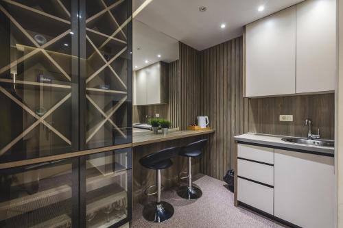 a kitchen with a bar stool and a sink at Harmony Apartments in Podgorica