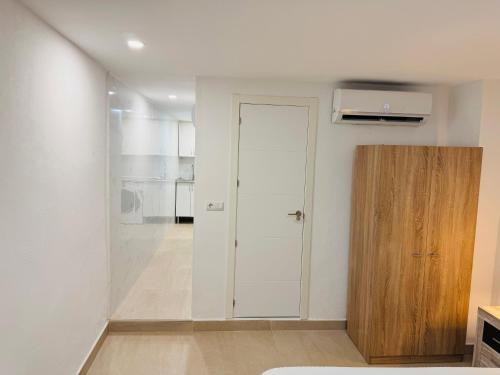 a white room with a door and a wooden cabinet at Loft muy céntrico a 250m del mar in Vinaròs