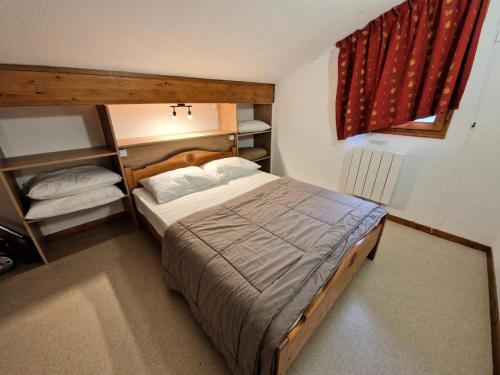 une petite chambre avec un lit et une fenêtre dans l'établissement Les Chalets D'arrondaz - Joli duplex 10/12 personnes MAE-2892, à Modane