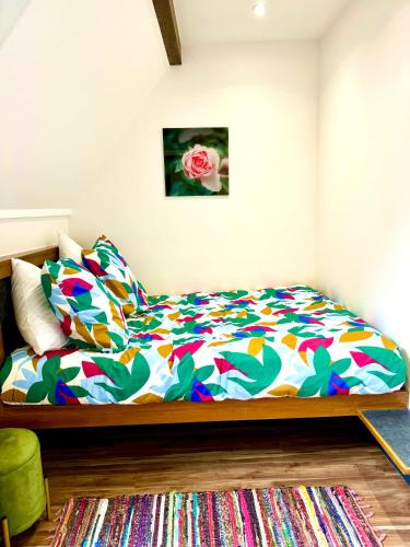 une chambre avec un lit avec une couette colorée dans l'établissement Petite maison calme limite Paris, à Saint-Ouen