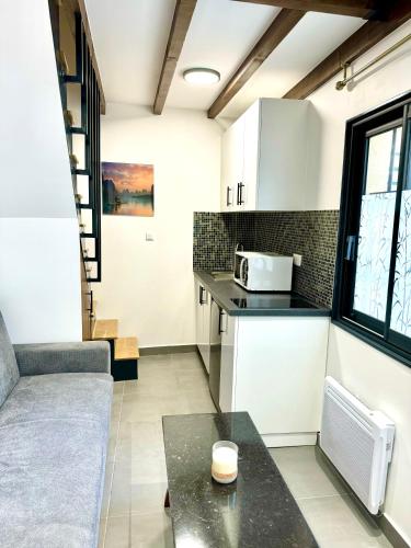 - une cuisine avec un canapé et une table dans une chambre dans l'établissement Petite maison calme limite Paris, à Saint-Ouen