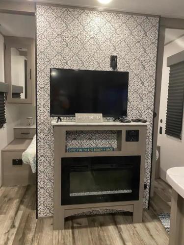 a living room with a fireplace with a flat screen tv at RV by the Sea - Glamping in the Keys - Sleeps 6 in Key Largo