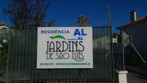ein Schild an einem Zaun vor einem Haus in der Unterkunft Hostel Jardins de São Luís in Setúbal