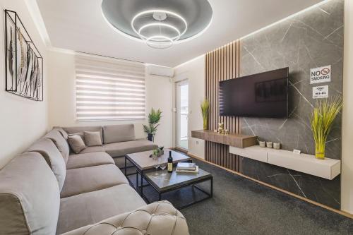a living room with a couch and a flat screen tv at Harmony Apartments in Podgorica
