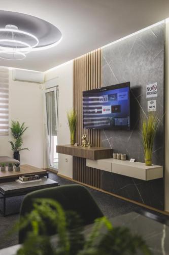 a living room with a flat screen tv on a wall at Harmony Apartments in Podgorica