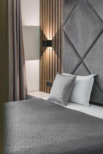 a bedroom with a bed with two pillows at Harmony Apartments in Podgorica