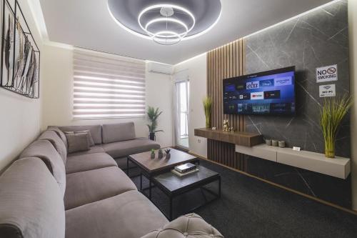 a living room with a couch and a flat screen tv at Harmony Apartments in Podgorica
