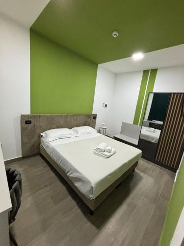 a bedroom with a large bed and a green wall at Il Vicoletto Bovalino - B&B in Bovalino Marina