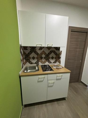a small kitchen with a sink and a stove at Il Vicoletto Bovalino - B&B in Bovalino Marina