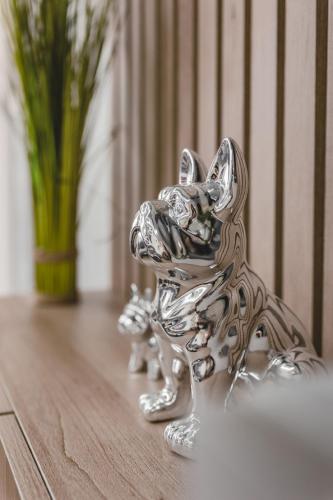 a silver dog figurine on a table with a vase at Harmony Apartments in Podgorica