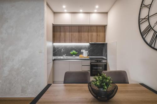 a kitchen with a wooden table and chairs and a kitchen with a sink at Harmony Apartments in Podgorica