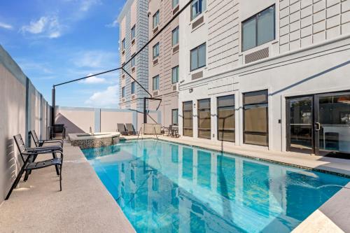 a swimming pool with chairs next to a building at Comfort Suites Laredo - Nuevo Laredo in Laredo