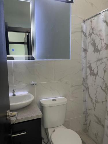 Un baño blanco con inodoro y lavabo. en Casa hermosa con piscina, en Salinas