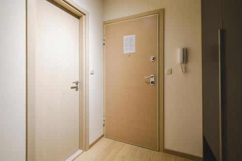 an empty corridor with a wooden door in a room at Harmony Apartments in Podgorica
