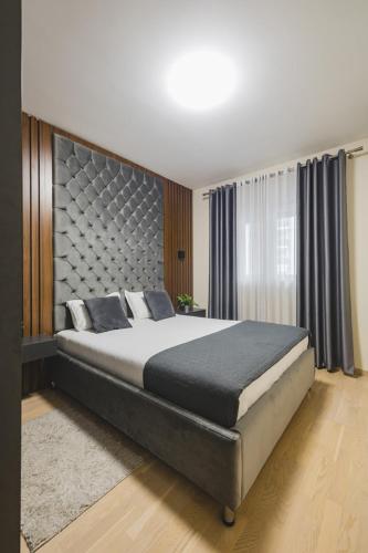 a bedroom with a large bed with a large headboard at Harmony Apartments in Podgorica