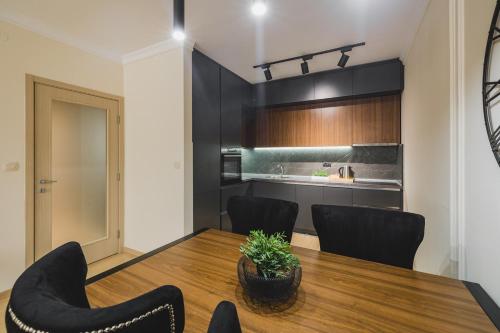 a dining room with a table and chairs and a kitchen at Harmony Apartments in Podgorica