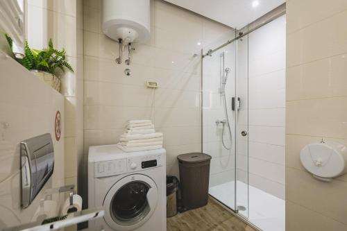 a bathroom with a washing machine and a shower at Harmony Apartments in Podgorica