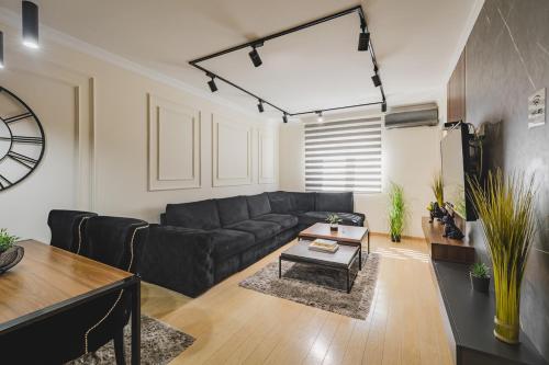 a living room with a black couch and a table at Harmony Apartments in Podgorica