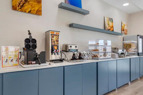 a kitchen with blue cabinets and appliances on a counter at Comfort Suites Laredo - Nuevo Laredo in Laredo