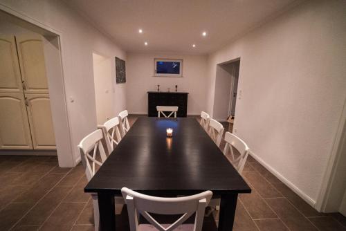 a dining room with a black table and white chairs at Gästehaus am Paradieshof in Schwerin