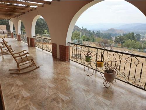 einen Balkon mit Stühlen und Bergblick in der Unterkunft Hospedaje El Tayo - Casa de campo Cajamarca in Cajamarca