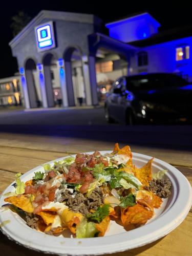 een bord eten op een tafel met een pizza bij Boardwalk Suites Lafayette in Lafayette