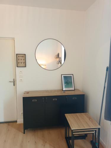 Cette chambre comprend une table et un miroir mural. dans l'établissement Le petit malouin, à Saint-Malo