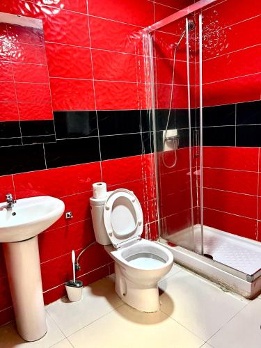 a red bathroom with a toilet and a sink at Hostal Gracias in Madrid