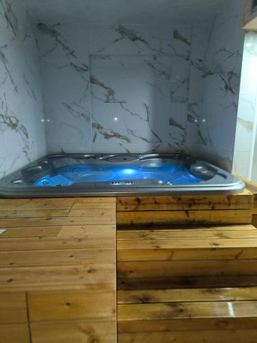 a blue tub in a bathroom with a marble wall at 4Rest & 4Joy in Zlatibor
