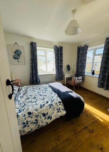 a bedroom with a bed and a desk and windows at 3 bedroom cottage Brecon sleeps 4 in Brecon